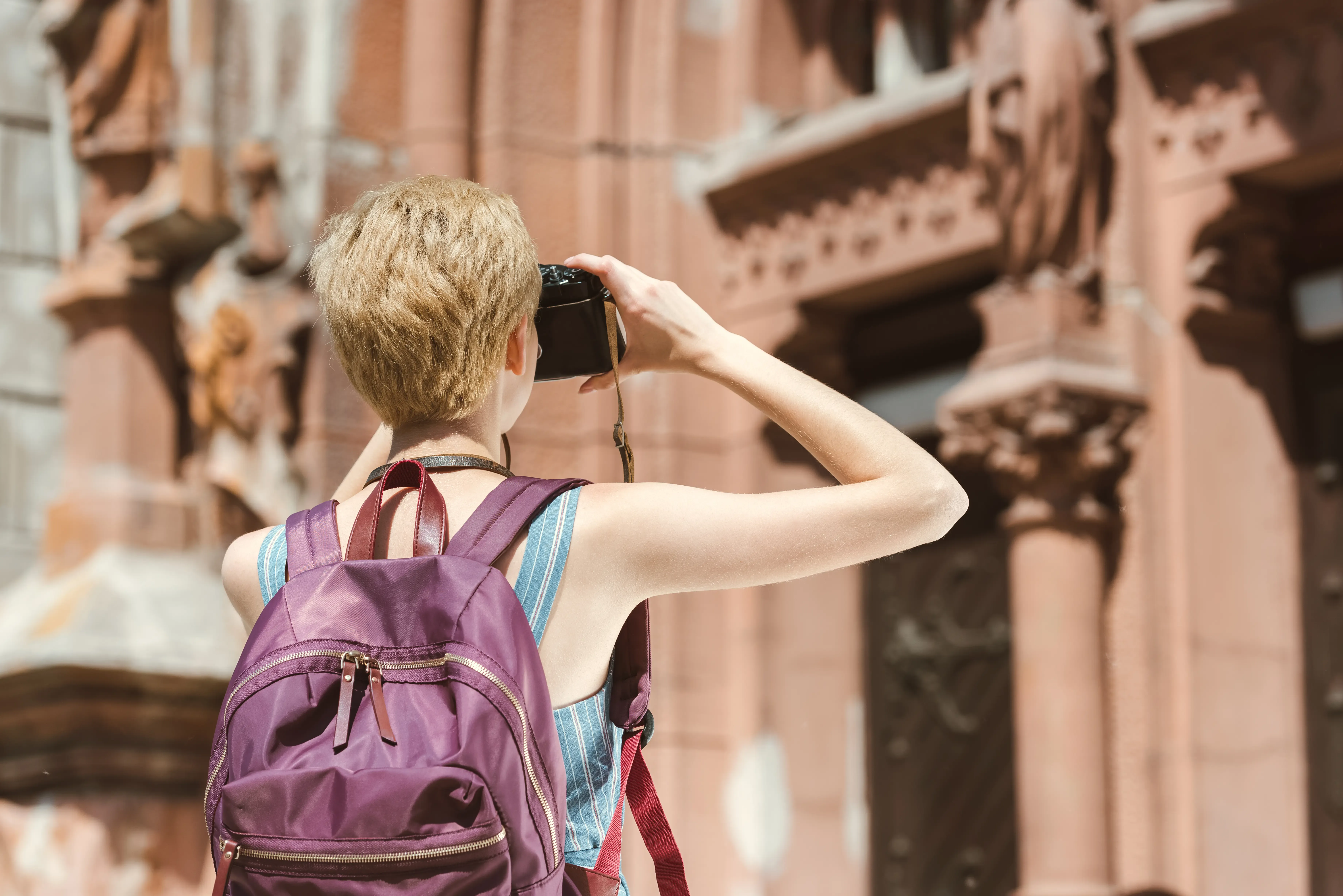 back-view-of-tourist-with-backpack-taking-photo.webp