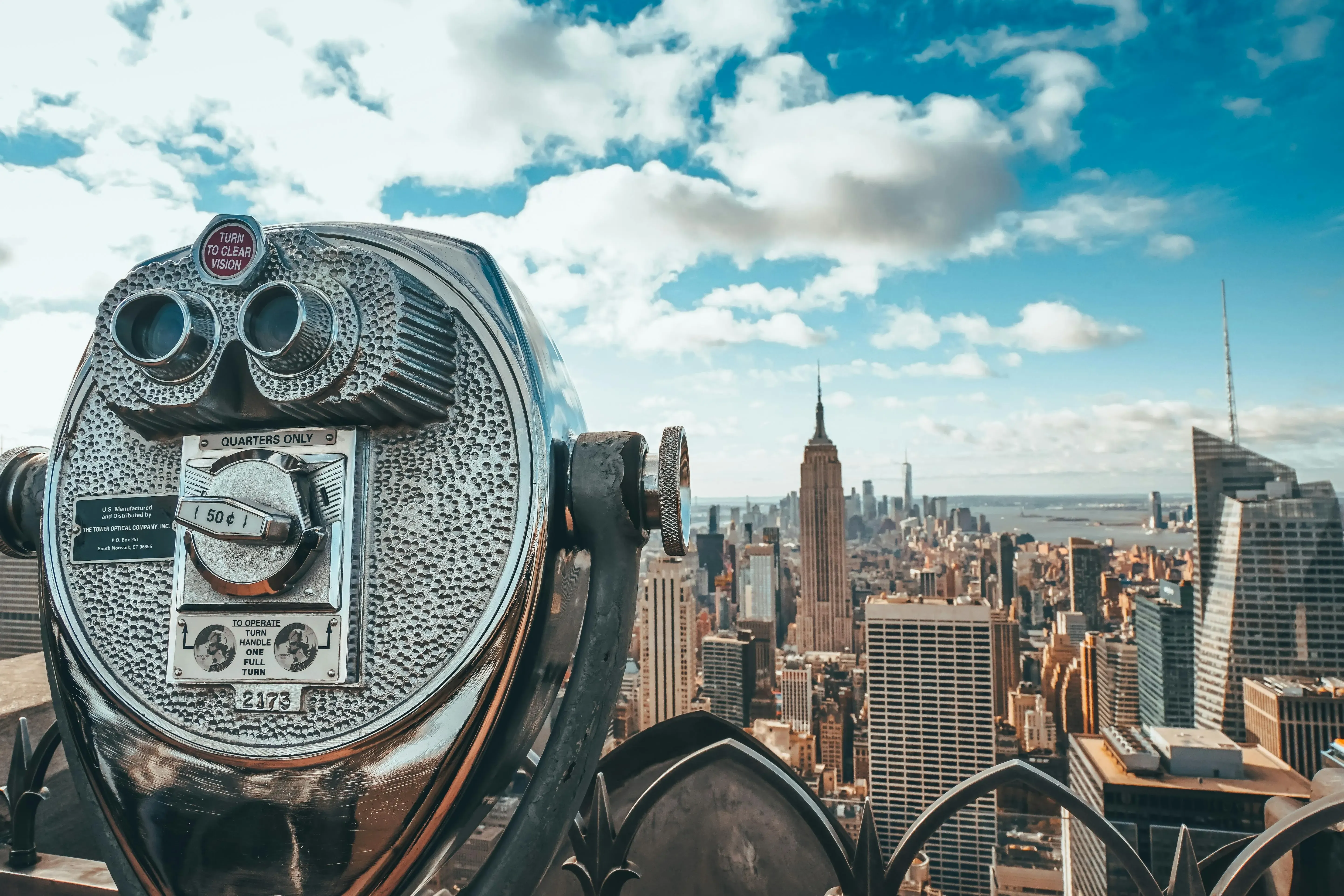 The Empire State Building towering over Manhattan, with a clear blue sky as the backdrop.